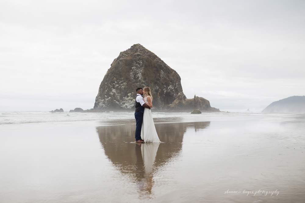 wedding couple in front of haystack rock at their cannon beach wedding